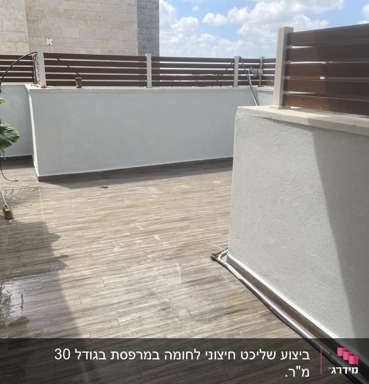 מרפסת עם רצפת עץ וצמחייה בצד
